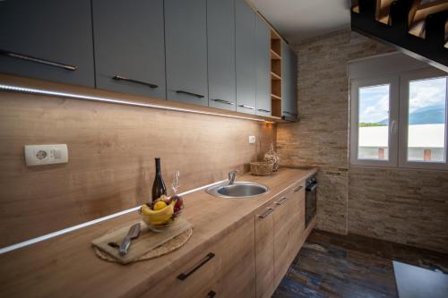 a kitchen counter with a sink and a bottle of wine at Family House Bjelila in Tivat