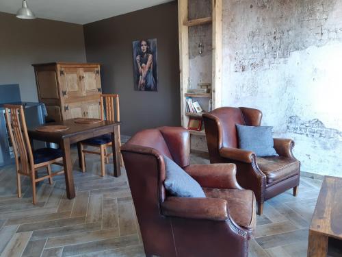 salon ze skórzanymi krzesłami i stołem w obiekcie Gîte Côté Nature w mieście Cabrerolles
