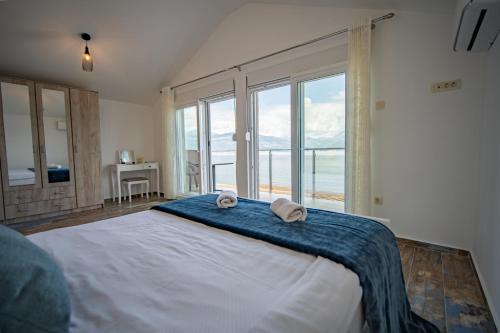 a bedroom with a large bed with two towels on it at Family House Bjelila in Tivat