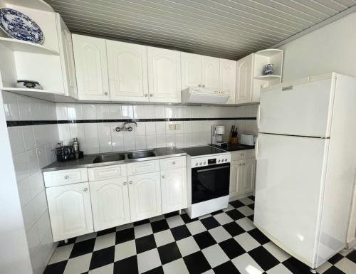 a kitchen with a white refrigerator and a checkered floor at Sunset Haven in Poros