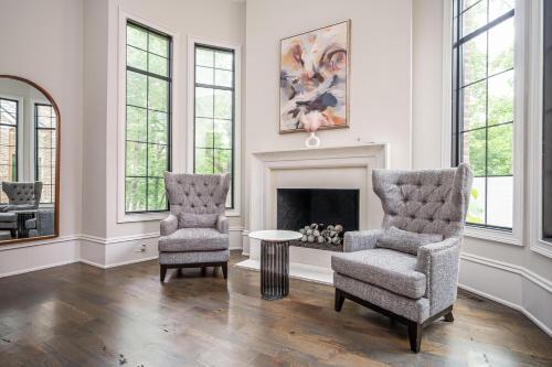 a living room with two chairs and a fireplace at Adams Mansion, 10K Sqft, 7BD/7BA, 15min to Airport in Atlanta