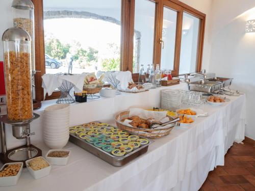 un buffet di cibi su un tavolo bianco di Hotel Pedra Santa a Baja Sardinia