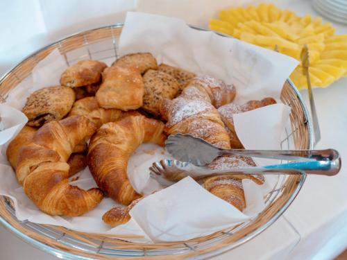 un cestino di pane e dolci su un tavolo di Hotel Pedra Santa a Baja Sardinia
