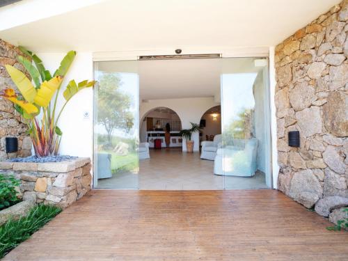 an open door to a house with a stone wall at Hotel Pedra Santa in Baja Sardinia