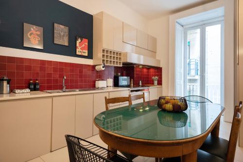 cocina con mesa de cristal y sillas en una habitación en De deo 98-modern hospitality-, en Nápoles