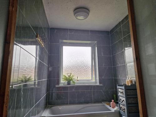 a bathroom with a bath tub and a window at Therence Accommodations can sleep up to 4 Guests in Chesterton, Stoke on Trent in Longport