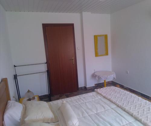 a bedroom with two beds and a wooden door at Cantinho Verde in Sertã