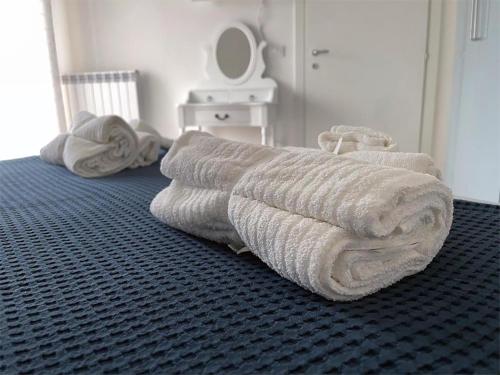 een stapel handdoeken ligt op een bed bij A casa di Ada [127] in Pescara