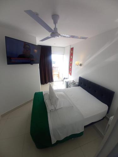 a bed in a room with a ceiling fan at Hotel Riviera Inka Paracas in Paracas