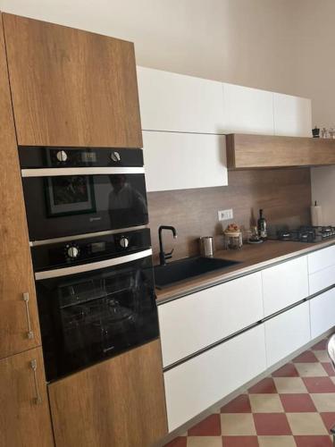 a kitchen with white cabinets and a black oven at Ale e Nino in Chieti