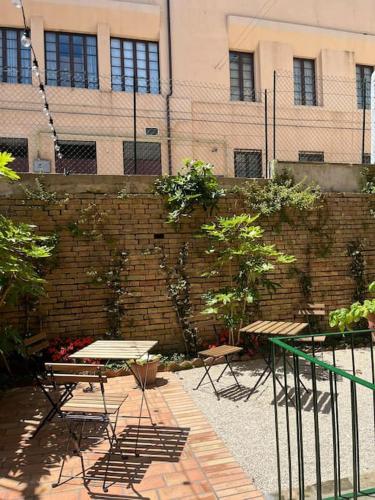 a patio with tables and chairs in front of a brick wall at Ale e Nino in Chieti