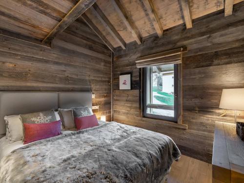 - une chambre avec des murs en bois et un grand lit dans l'établissement Duplex moderne proche pistes avec terrasse et parking privatif - FR-1-566-42, à Les Allues