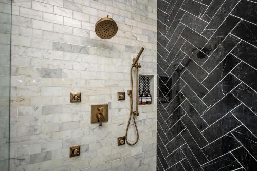 a bathroom with a shower with black and white tiles at Adams Mansion, 10K Sqft, 7BD/7BA, 15min to Airport in Atlanta