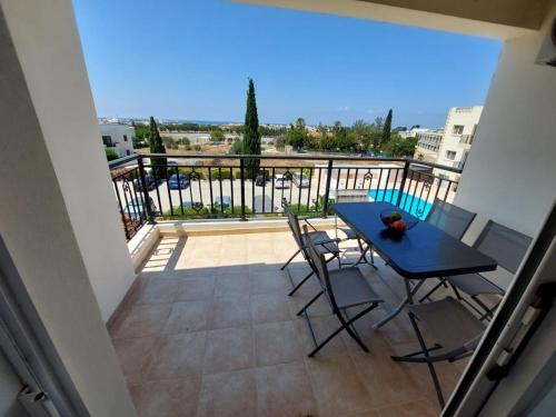 a balcony with a table and chairs and a view at Stunning views' Apartment with Pool in Paphos