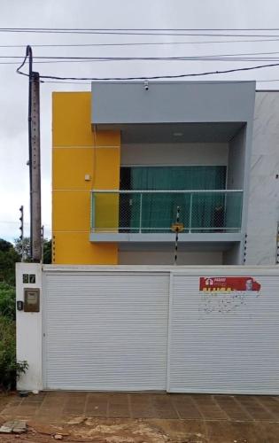 a building with a white garage door with a balcony at Casa Duplex - Garanhuns in Garanhuns