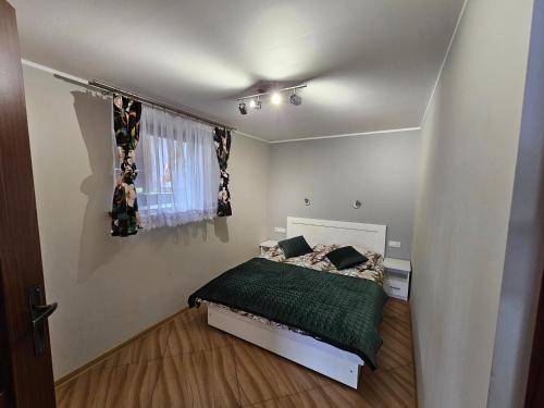 a small bedroom with a bed and a window at Smile Apart in Biały Dunajec