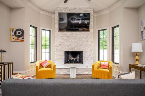 a living room with two chairs and a fireplace at Adams Mansion, 10K Sqft, 7BD/7BA, 15min to Airport in Atlanta