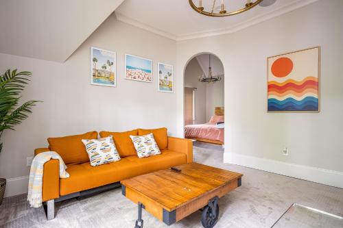 a living room with an orange couch and a coffee table at Adams Mansion, 10K Sqft, 7BD/7BA, 15min to Airport in Atlanta