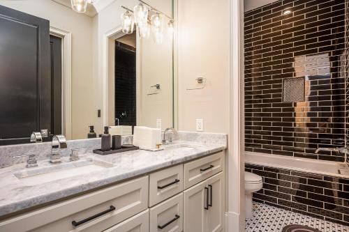 a bathroom with a sink and a toilet and a mirror at Adams Mansion, 10K Sqft, 7BD/7BA, 15min to Airport in Atlanta