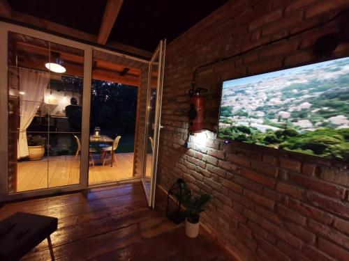 DOMAGAŁA domek całoroczny في واغوف: غرفة معيشة مع تلفزيون على جدار من الطوب