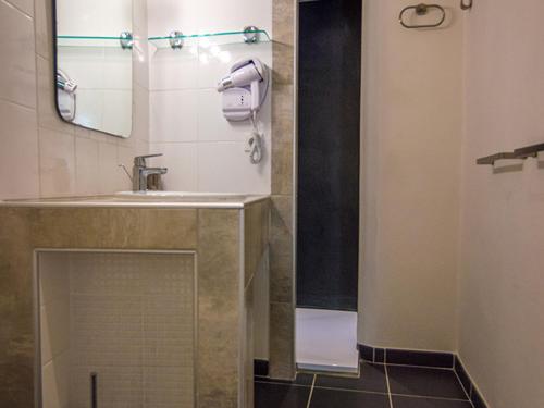 uma casa de banho com um lavatório e um espelho em Appartement Mèze, 3 pièces, 4 personnes - FR-1-604-2 em Mèze