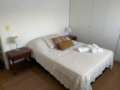 ein Schlafzimmer mit einem Bett mit zwei Nachttischen und zwei Lampen in der Unterkunft Encantador apartamento en Malvín in Montevideo