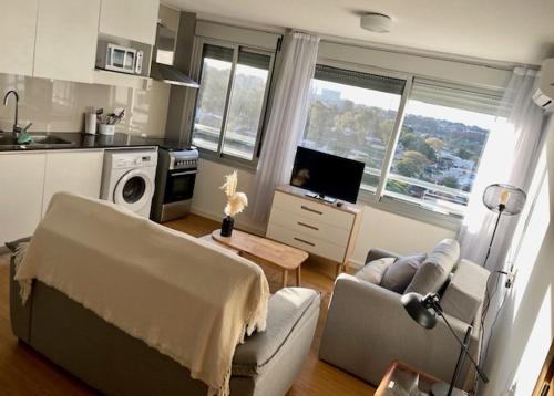 ein Wohnzimmer mit einem Sofa und einem Tisch in der Unterkunft Encantador apartamento en Malvín in Montevideo