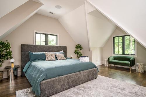 a bedroom with a large bed and a green chair at Adams Mansion, 10K Sqft, 7BD/7BA, 15min to Airport in Atlanta