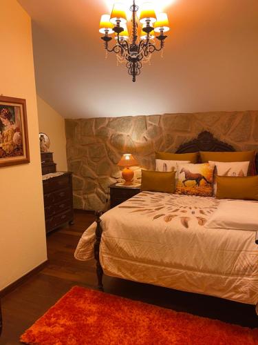 Un dormitorio con una cama grande y una lámpara de araña. en Villa Safari Charm, en Ribeira Brava