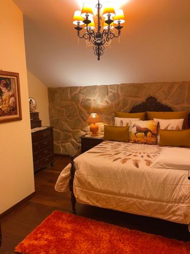 a bedroom with a large bed and a chandelier at Villa Safari Charm in Ribeira Brava