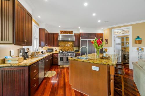 a large kitchen with wooden cabinets and a counter top at 1730 Kaleka 4 Bed Poipu House, Guest House walk to Beach in Koloa