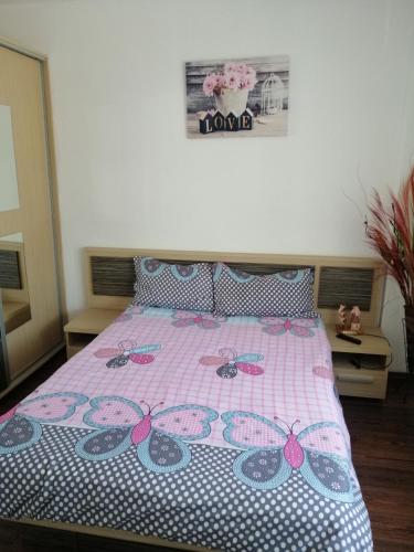 a bedroom with a bed with a pink and white bedspread at Modernul apartament de lângă Castel in Hunedoara