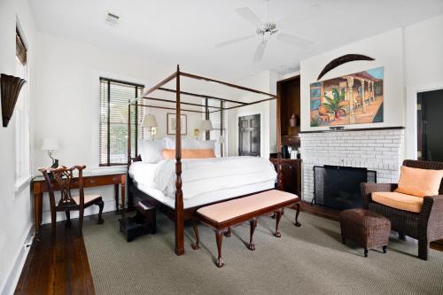 um quarto com uma cama de dossel e uma lareira em Rhett House em Beaufort