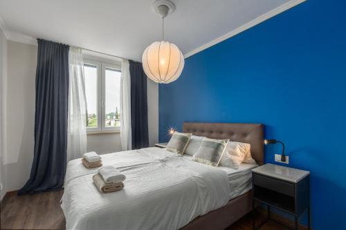una camera blu con un grande letto con una parete blu di Saint Vitus Apartment a Rovigno (Rovinj)