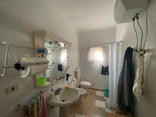 bagno con servizi igienici bianchi e lavandino di House Edda Serena - Casa Vacanze Salerno a Pontecagnano