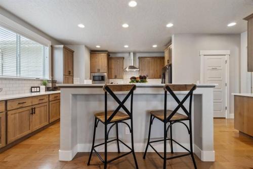 a kitchen with two bar stools at a counter at The Dream Home with 5 bedrooms in Meridian ID in Meridian