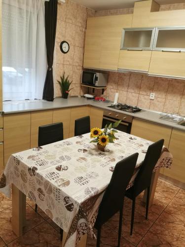 a kitchen with a table with a vase of flowers on it at Modernul apartament de lângă Castel in Hunedoara