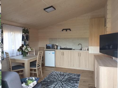 a kitchen and dining room with a table and a television at Serce Puszczy Wiartel in Wiartel