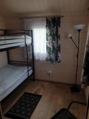 a small room with bunk beds and a window at Serce Puszczy Wiartel in Wiartel