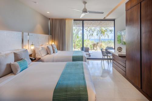 um quarto de hotel com duas camas e uma grande janela em The Club at Solaz Luxury Villas em San José del Cabo