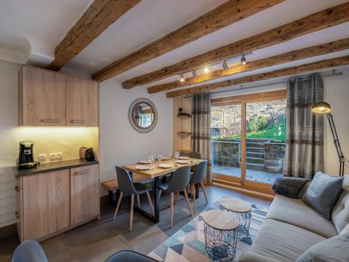 une cuisine et un salon avec une table et un canapé dans l'établissement Chalet cosy au Raffort avec jardin, proche télécabines et bus, parking, animaux admis - FR-1-566-47, à Les Allues