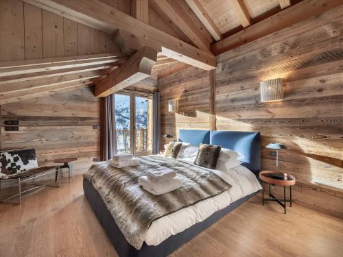 a bedroom with a large bed with wooden walls at Chalet avec jacuzzi, proche des pistes, pour 10 personnes - FR-1-570-20 in Saint-Martin-de-Belleville