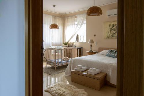 a bedroom with a bed and a crib in it at Villa Abelos in Artemida