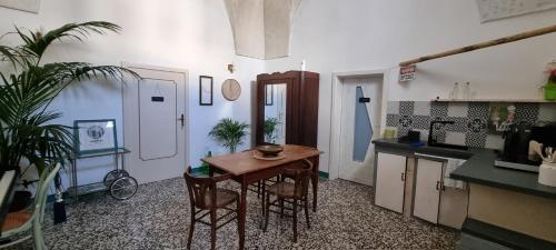 een keuken met een tafel en stoelen in een kamer bij Boemio 30 - B&B Coliving in Galatina