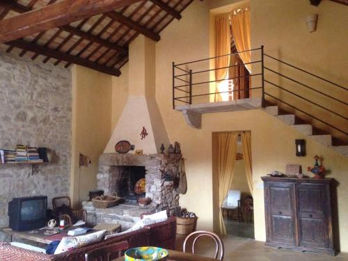 uma sala de estar com uma escada e uma lareira de pedra em CASA Adriana Affascinante casa in pietra em Buseto Palizzolo