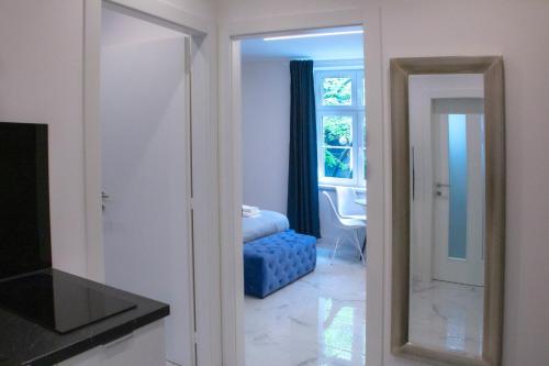 een kamer met een spiegel en een blauwe poef bij Apartman Godot in Zagreb