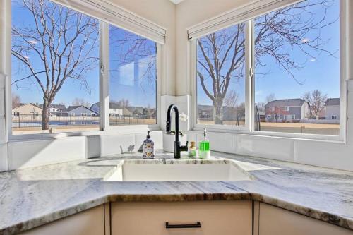 a kitchen with a sink and two windows at The White Custom Farmhouse 5 bedroom Home in Meridian
