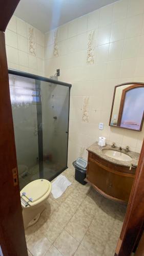 a bathroom with a shower and a toilet and a sink at Suíte aconchegante II in Cruzeiro