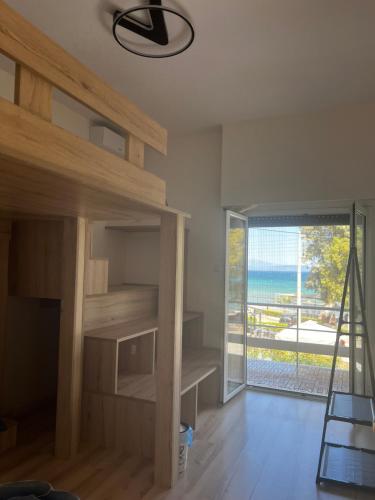 a room with wooden shelves and a sliding glass door at 一线海景房seaview apartment in Artemida