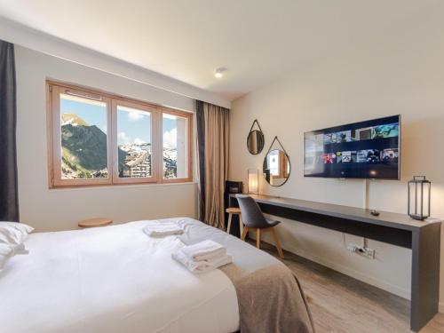 a hotel room with a bed and a desk and a tv at Superbe appartement 56m², accès pistes, terrasse sud, 1 suite parentale, proche centre et ESF - FR-1-634-5 in Avoriaz
